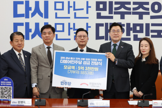 더불어민주당 박찬대 당대표 직무대행 겸 원내대표와 김병욱 중앙당후원회장이 15일 서울 여의도 국회에서 신훈 희망브리지 사무총장에게 '경북·경남·울산 지역 산불 피해 지원을 위한 더불어민주당 성금'을 전달한 뒤 기념촬영 하고 있다. 왼쪽부터 김병주 의원, 김병욱 중앙당후원회장, 신훈 희망브리지 사무총장, 박찬대 직무대행, 김희윤 희망브리지 모금사업팀장.<연합뉴스 사진>